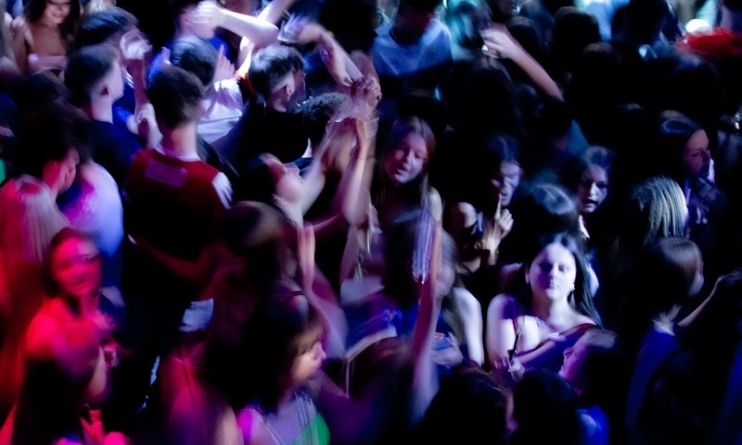 Layla Tobin: Seasons Of My Youth | Thursday 19 September – Saturday 5 October 2024 | The Source Arts Centre | Image: probably a photo of teens packed onto a dance floor; magenta light from the left, though it doesn't reach far; white light from the right; motion blur on some of the figures 