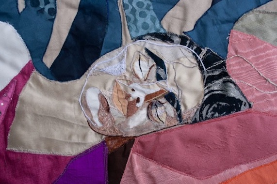 Olga Anacka: Nap in the Grandma’s Room (detail) | Olga Anacka: Patching Femininity | Thursday 26 September – Friday 25 October 2024 | Limerick City Gallery | Image: Olga Anacka: Nap in the Grandma’s Room (detail) | this is a tapestry; we see head and shoulders (more or less) of a figure who is asleep, head on a pillow or cushion; black hair, black eyebrows, pale sckin, colourful top, patches of different colours behind 