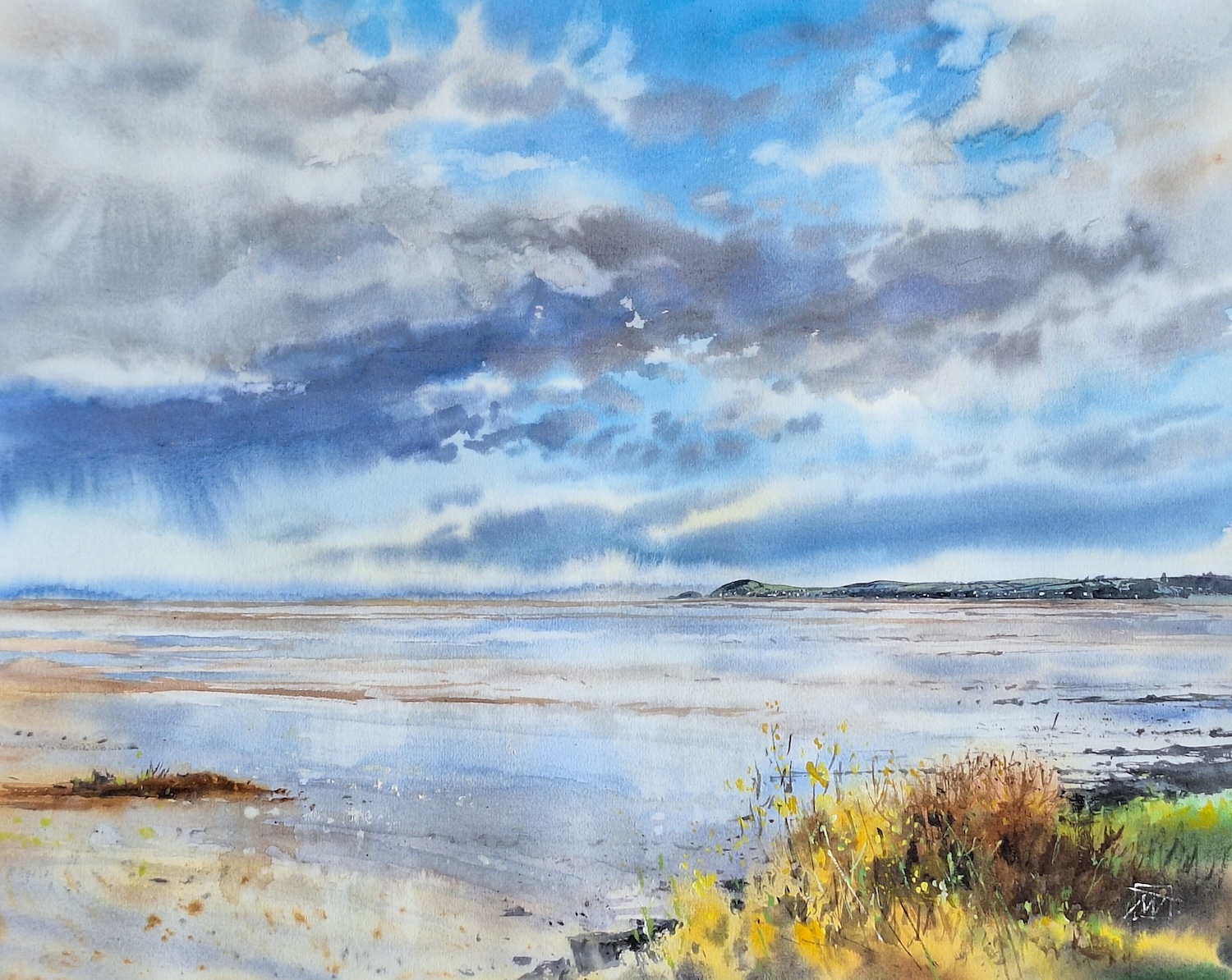 Tetiana Milshyna: Low Tide, Dungarvan Harbour,  watercolour | Tetiana Milshyna: Studios of Sanctuary | Friday 10 January – Tuesday 4 February 2025 | Triskel Arts Centre | Image: Tetiana Milshyna: Low Tide, Dungarvan Harbour, watercolour; view out to sea on what seems to be a fine day with scattered clouds, with a hint of rain coming from one of them; vast expanse of beach before us, very wet in parts, reflecting the sky; headland off in the distance to the right; horizon about two-thirds of the way down the image; sign of possible land in the distance; view is from a grassy area above the beach – we see yellow flowers and yellow and brown grasses bottom right 