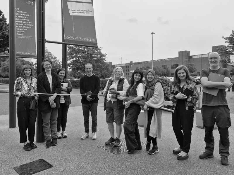 Together in Commune | Friday 27 June – Saturday 13 September 2025 | RUA RED | Image: black-and-white photos of presumably all the artists in the exhibition, smiling towards the camera outside RUA RED Together in Commune | Friday 27 June – Saturday 13 September 2025 | RUA RED | Image: black-and-white photos of presumably all the artists in the exhibition, smiling towards the camera outside RUA RED