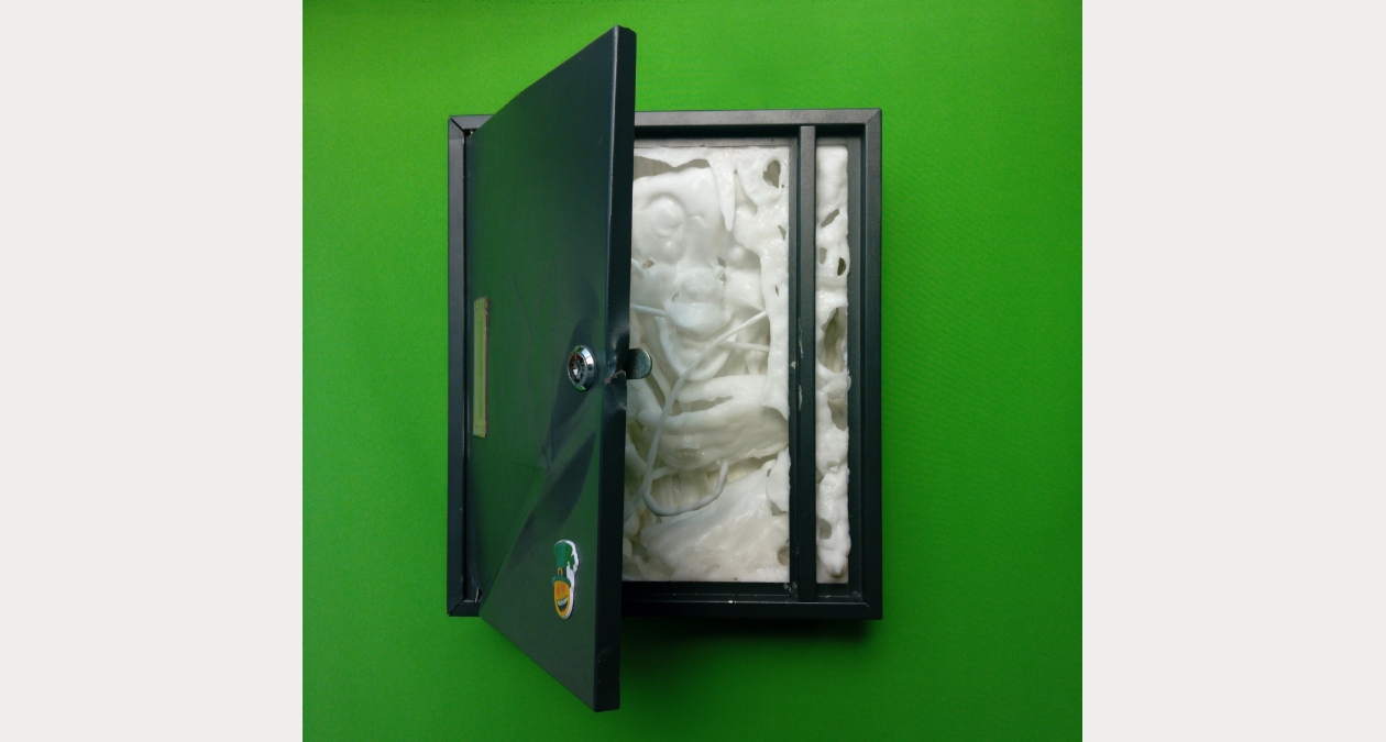 Alex de Roeck, Messenger, 2025, Polycaprolactone (PCL), steel, chain, Image courtesy of the artist | Alex de Roeck: Debt Wish | Friday 21 November – Sunday 21 December 2025 | Royal Hibernian Academy | Image: Alex de Roeck, Messenger, 2025, Polycaprolactone (PCL), steel, chain, Image courtesy of the artist | photo of what looks like a locker door on a very green wall; square door, open (it just takes a key), and inside we see a strange cross in white foam between a frog / duck / ? and a human, judging by the hands; we just see a head and hands, partially, as though pressed up against glass; there is a strange vertical bar towards the right of the opened space; door and frame around it are metallic black; there is a sticker of some sort on the door Alex de Roeck, Messenger, 2025, Polycaprolactone (PCL), steel, chain, Image courtesy of the artist | Alex de Roeck: Debt Wish | Friday 21 November – Sunday 21 December 2025 | Royal Hibernian Academy | Image: Alex de Roeck, Messenger, 2025, Polycaprolactone (PCL), steel, chain, Image courtesy of the artist | photo of what looks like a locker door on a very green wall; square door, open (it just takes a key), and inside we see a strange cross in white foam between a frog / duck / ? and a human, judging by the hands; we just see a head and hands, partially, as though pressed up against glass; there is a strange vertical bar towards the right of the opened space; door and frame around it are metallic black; there is a sticker of some sort on the door