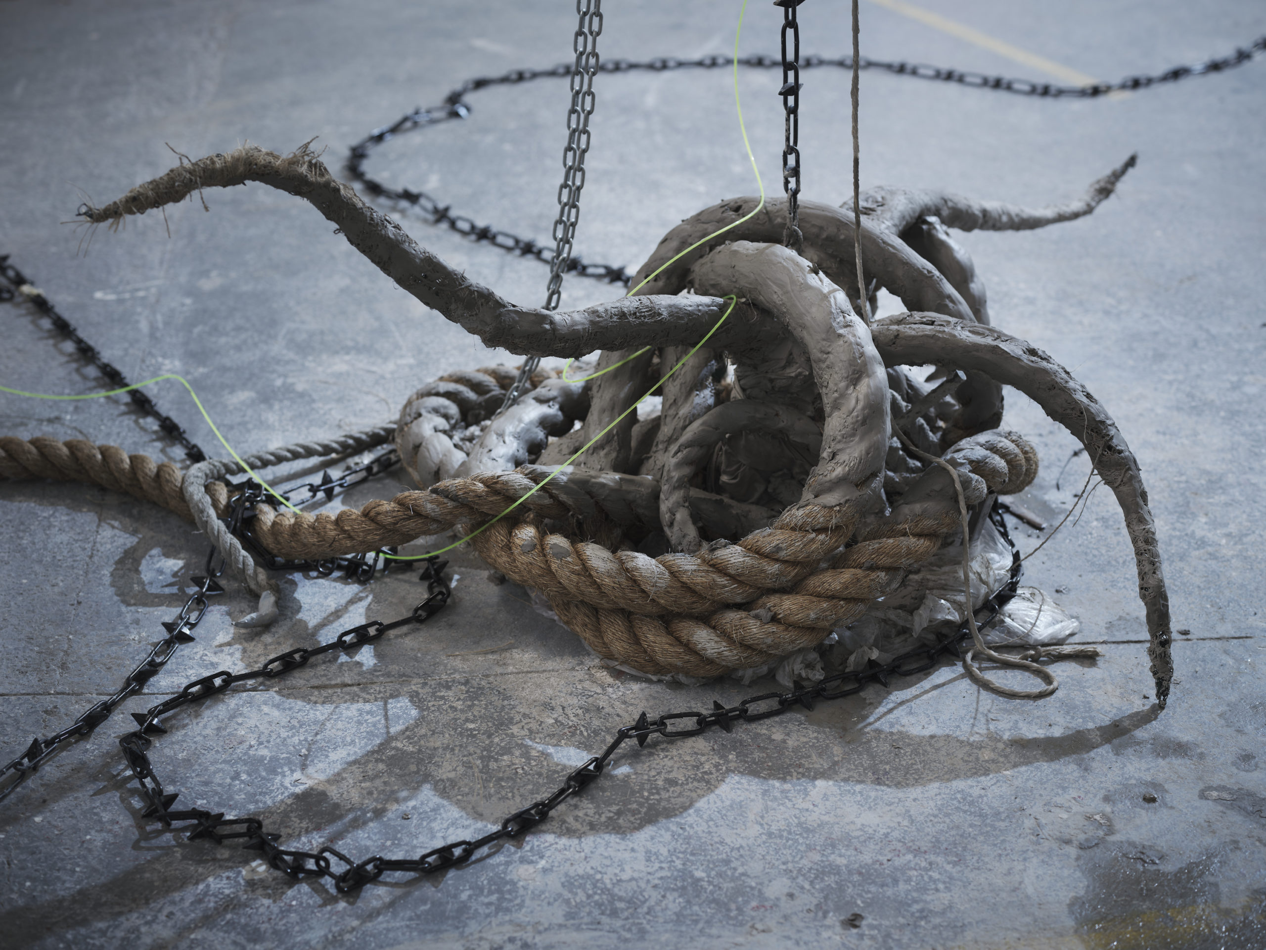 Cecilia Bullo, ‘She grew the tree plant, she grew the plant, she grew the primeval mother: The plants of lamentation have sprouted’, 2023. Courtesy of the artist. | Cecilia Bullo: Being Haunted by the Breezes, Now How Will You Exist? | Friday 17 February  – Sunday 23 April 2023 | Royal Hibernian Academy | Image: close-up of 3D artwork by Cecilia Bullo; ship's rope apparently morphing into clay-clad organic extrusions; a black metal chain loops through the assembly 