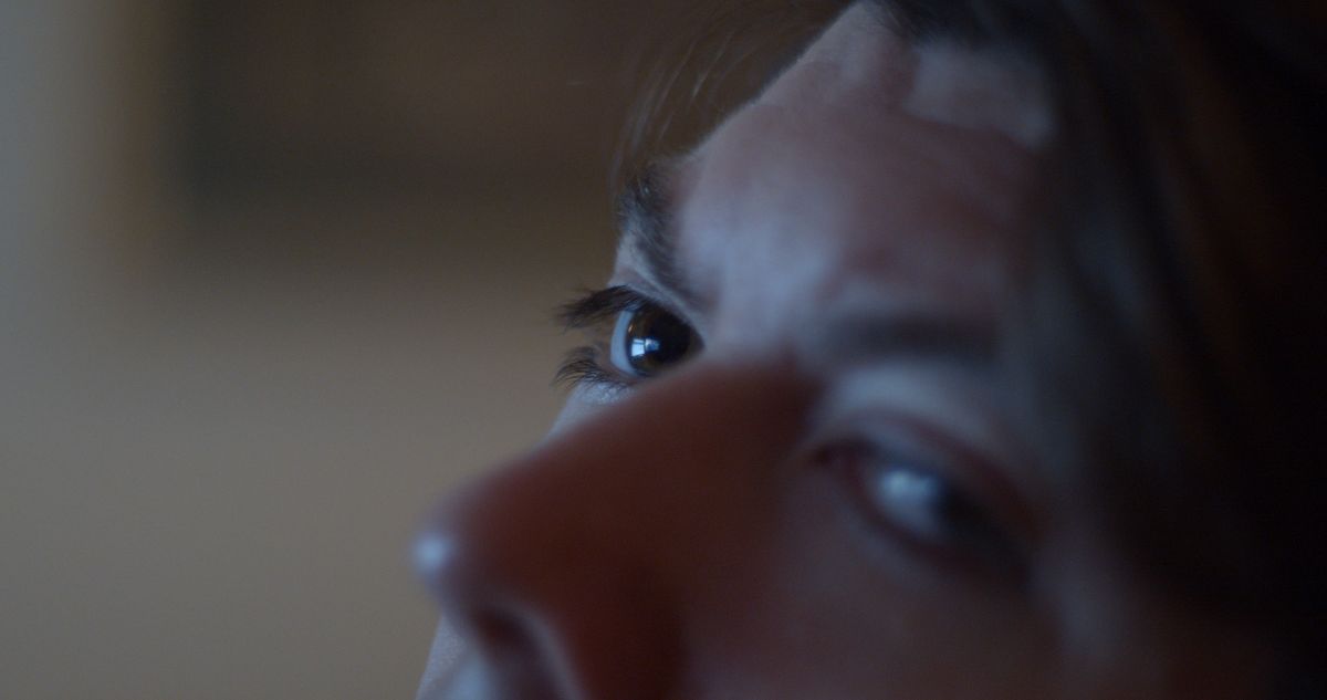 Holly Márie Parnell, Cabbage (still), 2022. Video, colour, sound, 28 minutes. Courtesy of the artist | Holly Márie Parnell: Cabbage | Saturday 18 March  – Saturday 15 April 2023 | SIRIUS | Image: Holly Márie Parnell, Cabbage (still), 2022. Video, colour, sound, 28 minutes. Courtesy of the artist – close-up of what appears to be a woman's upper face, with eyes looking sidewards towards the camera 