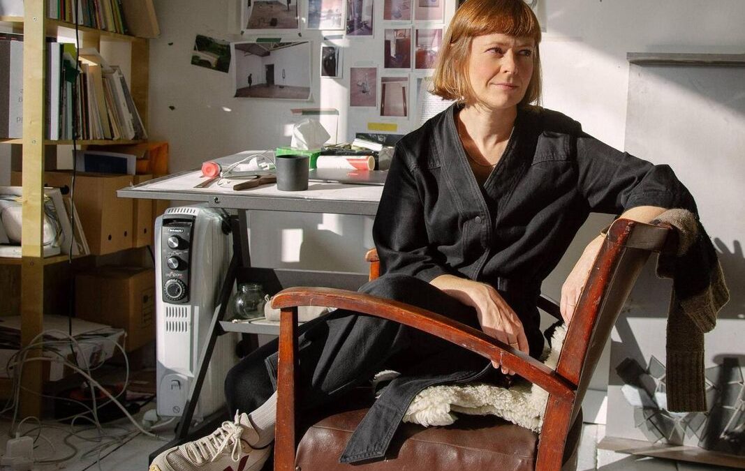 Niamh O’Malley: Gather Belfast | Saturday 29 April  – Saturday 24 June 2023 | Golden Thread Gallery | Image: photo of Niamh O'Malley, sitting sideways on a chair and looking off to her left, in a studio setting 