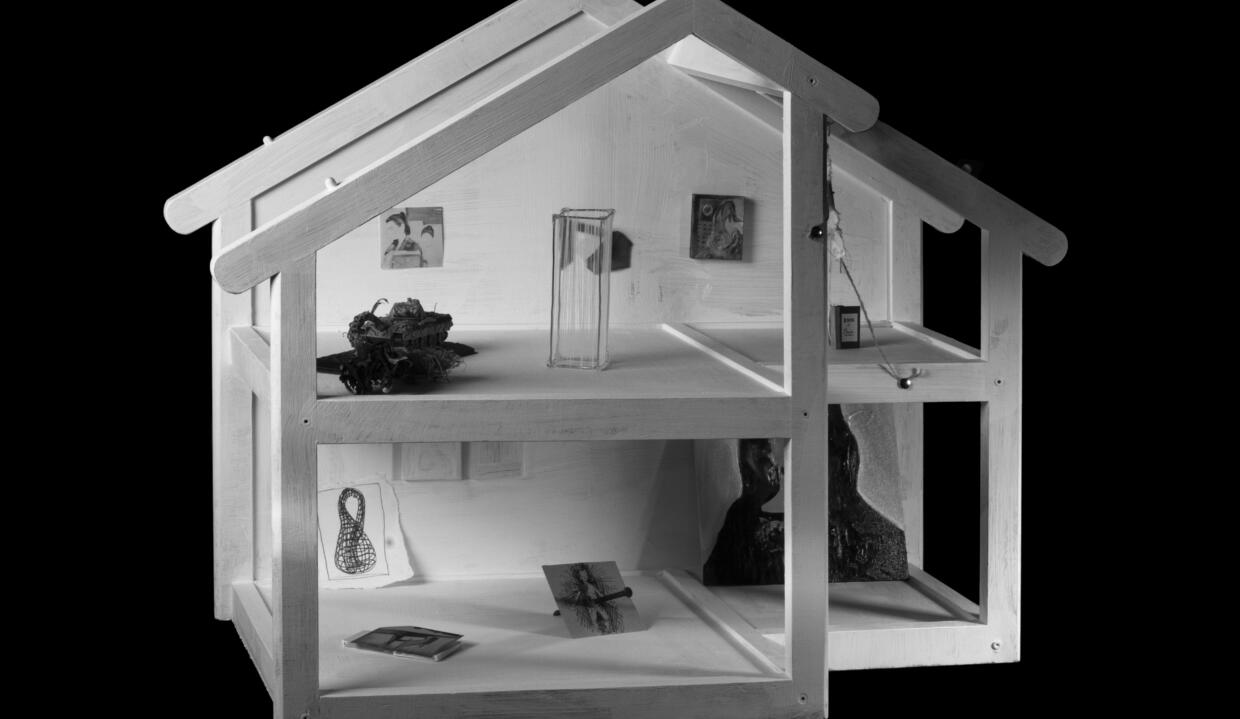 Photographed and edited by Marco Di Sante, model comprised of artifacts from each artists practice. | Bigger than Us: NCAD MFA 2023 | Thursday 4 May  – Tuesday 16 May 2023 | Rua Red | Image: Photographed and edited by Marco Di Sante, model comprised of artifacts from each artists practice – a 3D house constructed with what look like thick lollipop sticks possibly painted white; no walls; inside are indications of display spaces, with miniature token objects 