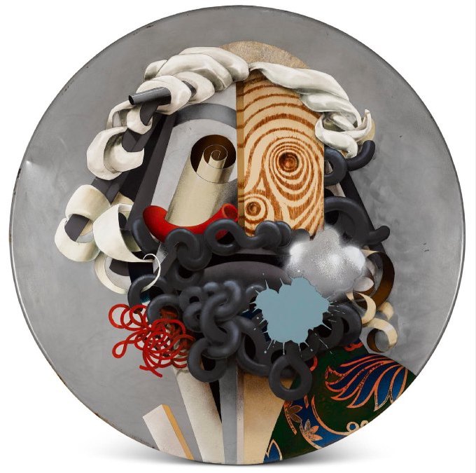 John Kindness, Head of Odysseus, 2010, enamel paint and oil on steel table top, 80cm diameter, image courtesy of the artist | John Kindness: The Odyssey | Friday 8 December 2023  – Sunday 18 February 2024 | Royal Hibernian Academy | Image: John Kindness, Head of Odysseus, 2010, enamel paint and oil on steel table top, 80cm diameter, image courtesy of the artist | Circular canvas. The head of Odysseus is painted as though put together from a diverse collection of materials, including a piece of wood whose grain serves to create a rudimentary eye and nose, a roll of material in perspective furnishing the second eye, and what look more or less like eel bodies that create the beard 