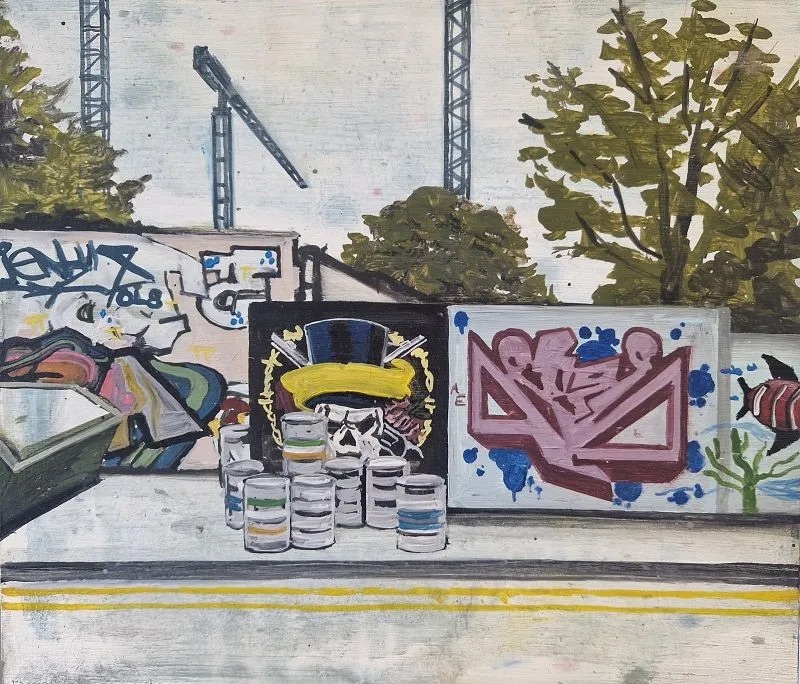 David Fox, Liberty Lane, oil on board, 25x29cm | David Fox: Urban Fingerprint | Friday 10 November  – Sunday 10 December 2023 | Olivier Cornet Gallery | Image: David Fox, Liberty Lane, oil on board, 25x29cm | we see an urban landscape, with construction cranes rising in the background and graffitied walls facing us; there’s a skip protruding in from the left, and beer barrels complete the task of blocking the footpath; we see part of the road, with double yellow lines; one of the graffiti features a skull wearing a top hat, with guns (?) crossed behind 