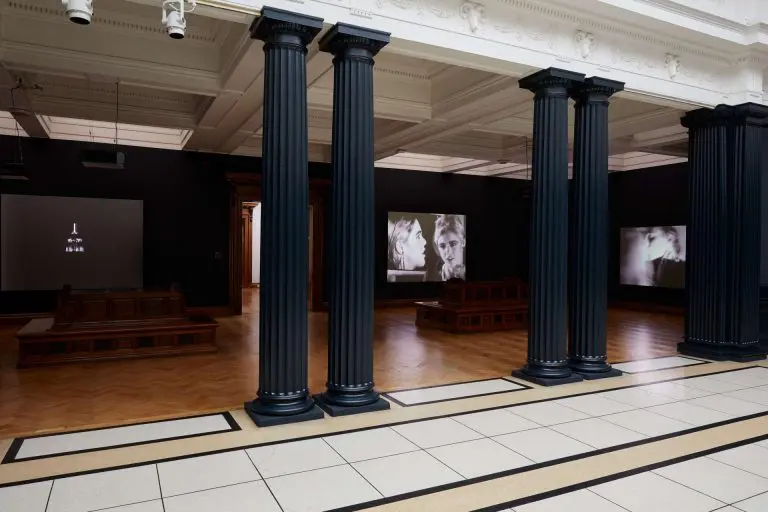 So, What? Andy Warhol Three Times Out Seminar | Friday 19 January 2024 | Hugh Lane Gallery | Image: photo taken in the main exhibition space in the older part of the Hugh Lane. In the foreground are two pairs of black columns, and farther back we see projections of two Warhol films against black walls.