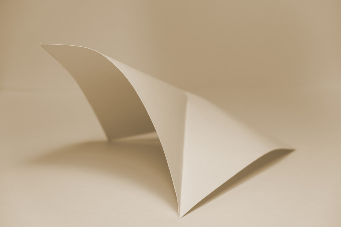 Mark Garry: to hold or to be held | Saturday 20 January  – Saturday 16 March 2024 | Solstice Arts Centre | Image: sepia-toned photo of what seems to be a folded piece of white card; gentle lighting with gentle shadows 
