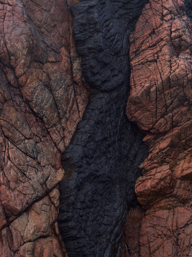 Ieva Kotryna Ski, Dyke#1, 2024 | Ieva Kotryna Ski: faults and folds | Saturday 13 April  – Saturday 29 June 2024 | CCA | Image: Ieva Kotryna Ski, Dyke#1, 2024 | it’s hard to know exactly what the image is of, but it seems to be a photo of black lava that has hardened in a pink-granite (?) cleft; it seems to be daytime, bright enough, and there is a suggestion of faint sunlight coming from the left 