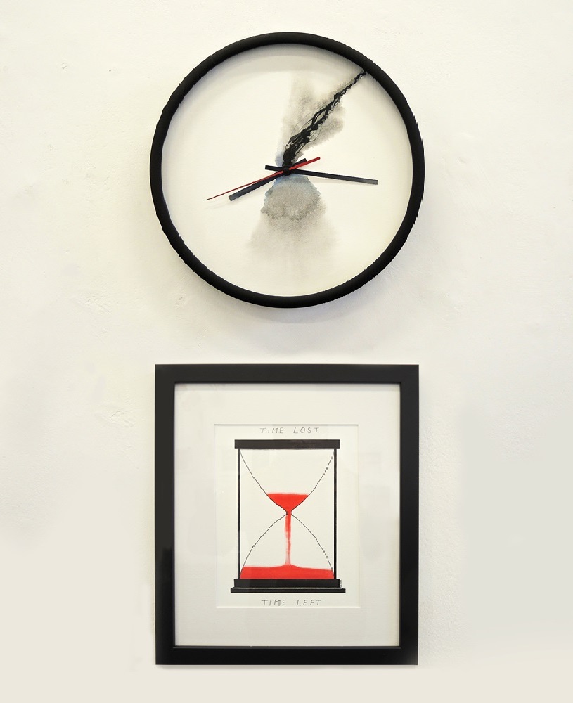 What do we want? | Sunday 7 April  – Friday 31 May 2024 | Olivier Cornet Gallery | Image: Gail Ritchie, Doomsday Clock, watercolour on paper with clock mechanism | the artwork is in two parts; above, there is a circular wall clock with a black frame and black hour and minute hands, but red second hand; there is also what appears to be an extra hand, long, black and scraggly, and there is what may be painting on glass or cotton wool under the hands, shaped somewhat like a cloud from an explosion; below is the watercolour painting, in an almost-square black frame with wide white mat; the watercolour is of a black egg-timer in which we see blood-red ‘sand’ which is close to running out 