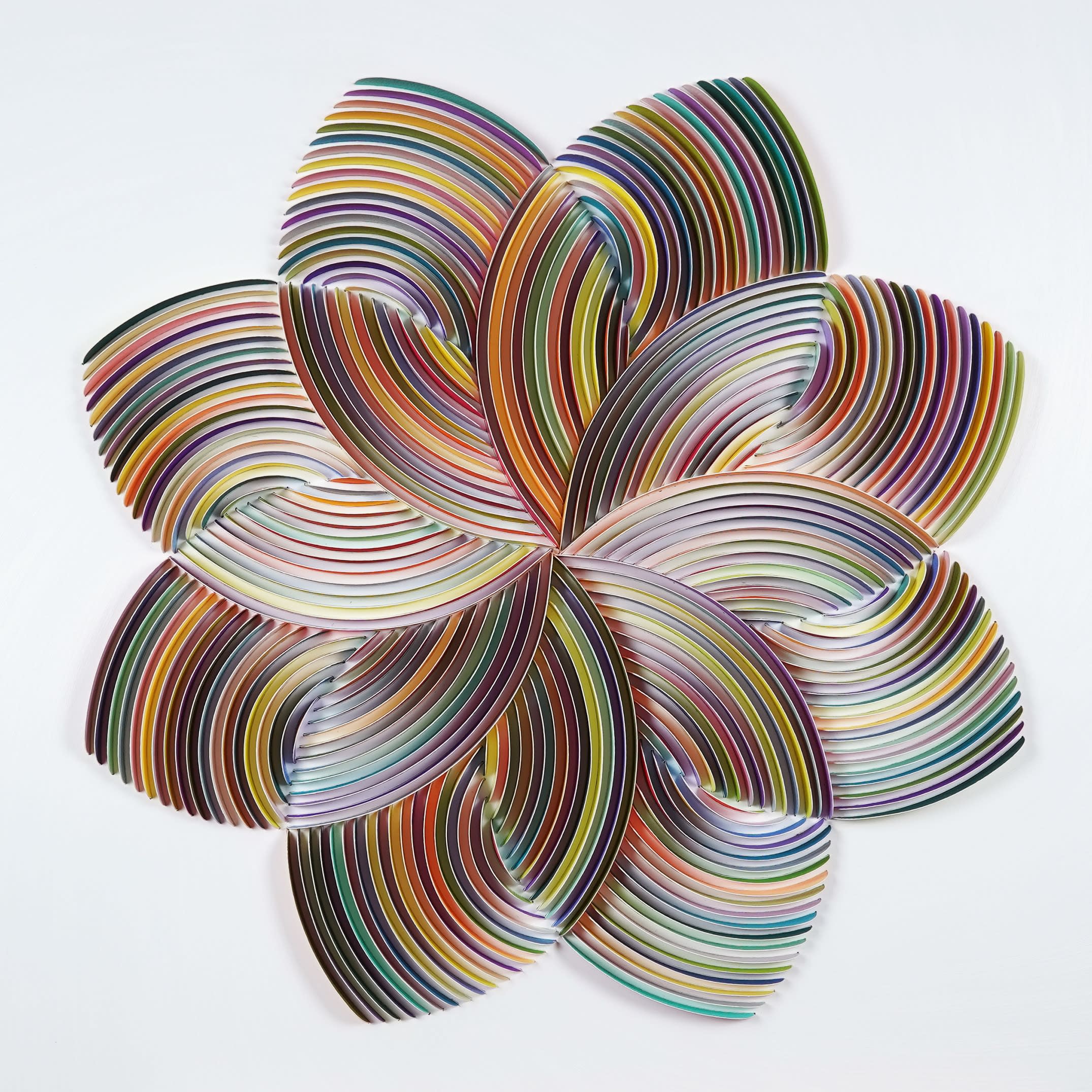 Peter Monaghan: Floret 16 points, Mixed Media, 27 1/2 x 27 1/2 in, 70 x 70 cm | Peter Monaghan: Perspectives | Thursday 18 April  – Tuesday 7 May 2024 | Gormleys Fine Art, Dublin | Image: Peter Monaghan: Floret 16 points, Mixed Media, 27 1/2 x 27 1/2 in, 70 x 70 cm | probably a work in cut, coloured paper, somewhat 3D; we see a flower shape – 8 petals ,and within that shape another set of eight thinner petals, rotated at 45 degrees to the first set; each petal is a series of parallel, sweeping coloured stripes 