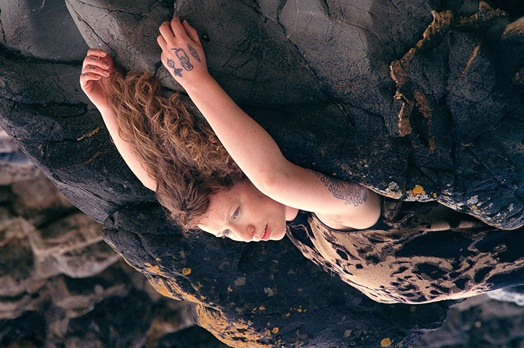

There is no weight I can't carry, medium format photograph, Caoimhín Gaffney, 2024

 | Caoimhín Gaffney: All at Once Collapsing Together | Saturday 8 June  – Sunday 28 July 2024 | Butler Gallery | Image: inverted (presumably) photo of a figure lying on rocks, probably by the seashore; we are viewing from the side and see the torso, head, long wavy reddish hair, and both arms stretched out ‘above’ the head (if the figure were standing, they would be above the head); on the back of the left hand there is a tattoo 