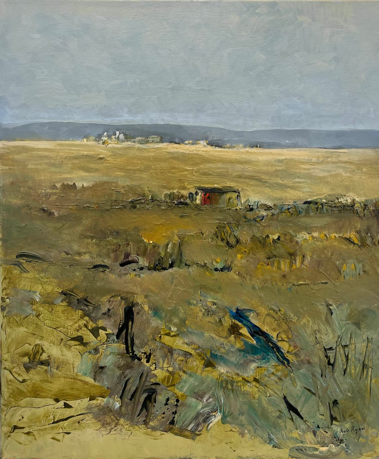 Bob Ryan: Alone, acrylic on canvas, 60 x 50 cm | Bob Ryan: A Legacy of Landscapes | Friday 5 July  – Saturday 20 July 2024 | Taylor Galleries | Image: Bob Ryan: Alone, acrylic on canvas, 60 x 50 cm |  landscape painting; it’s not clear where, but it looks like a dry climate; from far to near, there is a greyish-blue sky occupying about a quarter of the canvas, across the top; under it are medium-grey hills, then pale-wheat-coloured land with suggestions of rocky areas or of a village; closer to us is what may be a hut with a red door or panel; closer still to us, and in shadow, are suggestions of rough, grassy ground, with an indication of what may be a short water channel 