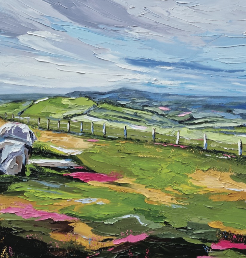 Fiona McKenna: A View from Loughcrew, 80 x 120cm | Fiona McKenna: Echoes of the Land | Monday 9 September  – Thursday 31 October 2024 | Toradh2 Gallery | Image: Fiona McKenna: A View from Loughcrew, 80 x 120cm | painting with quite heavy impasto, probably by palette knife; we see a rural landscape with a field in the foreground, two boulders to the left, a series of fenceposts cutting across the middle on a slight rising diagonal from left to right, with the leftmost posts farther from us; behind the fence are more fields, then low blue-ish hills; above is a grey and blue sky; the colours are pretty much what you would expect of an Irish landscape, with the exception of patches of pink, mostly in the foreground, sometimes quite saturated  