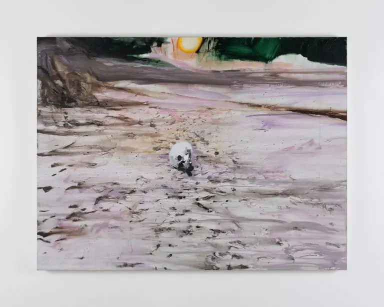 Brian Maguire, Arizona 2, 2020. Image courtesy Kerlin Gallery, Dublin. © Brian Maguire | Brian Maguire: La Grande Illusion | Thursday 3 October 2024  – Sunday 18 May 2025 | Hugh Lane Gallery | Brian Maguire, Arizona 2, 2020. Image courtesy Kerlin Gallery, Dublin. © Brian Maguire | the painting probably depicts the Arizona desert; we see dry, pale ground with possible footprints heading towards or away from us; in the distance are hills or shadows, a possible yellow-and-orange sun, and just possibly green vegetation; almost dead centre in the image is a human skull, minus lower jaw; it is resting on its right side, looking towards us with black eye sockets 
