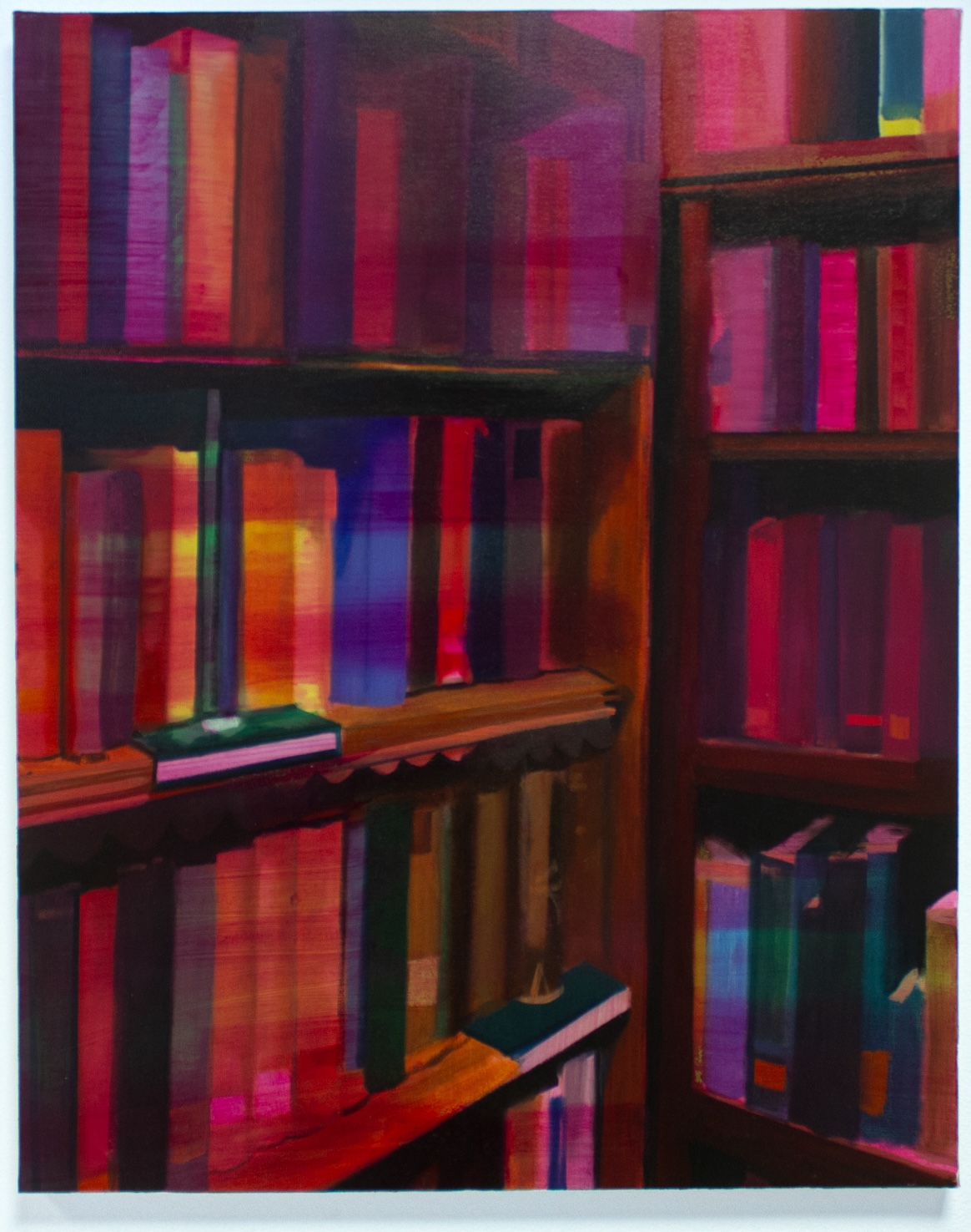 Lauren Conway: Draw a card | Thursday 30 January –    Sunday 9 March 2025 | Royal Hibernian Academy | Image: Lauren Conway, Draw a card, 2024, 60 x40cm, Oil on canvas, Image courtesy of the artist | painting of books arranged in an orderly fashiion on shelves; they are perhaps in a bookshop or library, a there appear to be lables on two of the shelves; the depiction is realistic, but the colour scheme is very unusual: it’s a though the shelves and books are floodlit with a crimson and purple light  