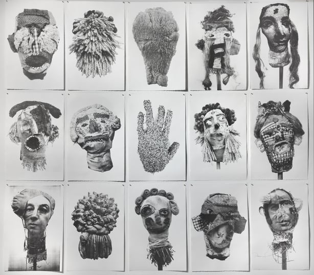 Image: Protestors, 2024, photograph by Roland Paschhoff, courtesy the artist and Source Arts Centre | Debbie Godsell: Flail | Saturday 22 February  – Saturday 5 April 2025 | Uillinn: West Cork Arts Centre | Image: Protestors, 2024, photograph by Roland Paschhoff, courtesy the artist and Source Arts Centre | black-and-white photo of photos (probably) pinned to a wall as three rows of five photos each; most of the photos depict a doll-like or ritual-related or goofy head; there is a photo of a furry hand right in the centre of the display; some of the heads are atop sticks; only one, bottom left, could be considered realistic, and two or three are far from discernable 