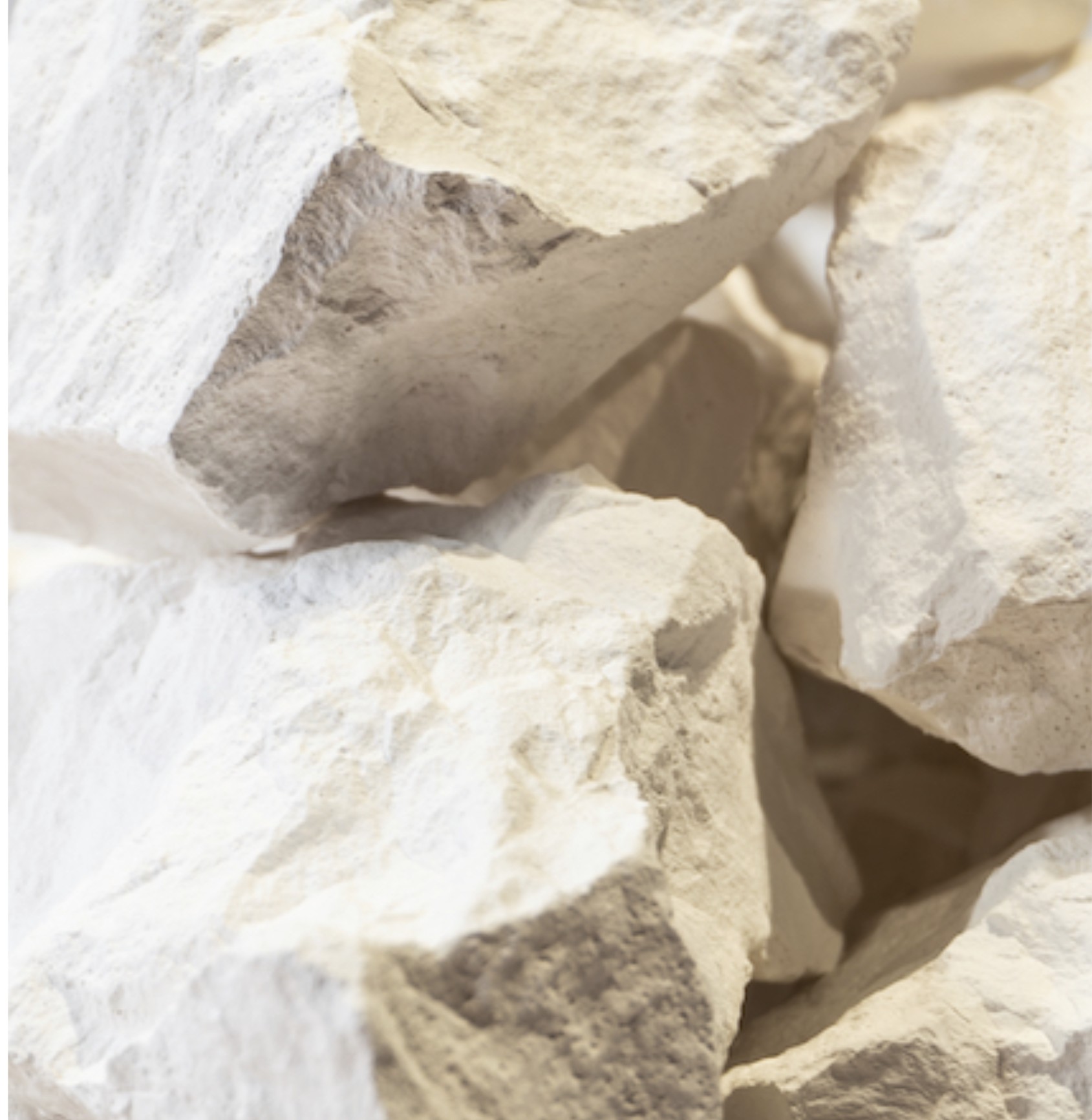 Courtesy of the artist | Stuart Calvin: Stay a While | Thursday 3 April  – Saturday 7 June 2025 | Golden Thread Gallery | Image: Courtesy of the artist | this appears to be a photo of rocks, as you might find in a quarry; white-ish, and as though they may have a powdery surface; the lighting – coming from various angles – suggests that they may be in a gallery setting 