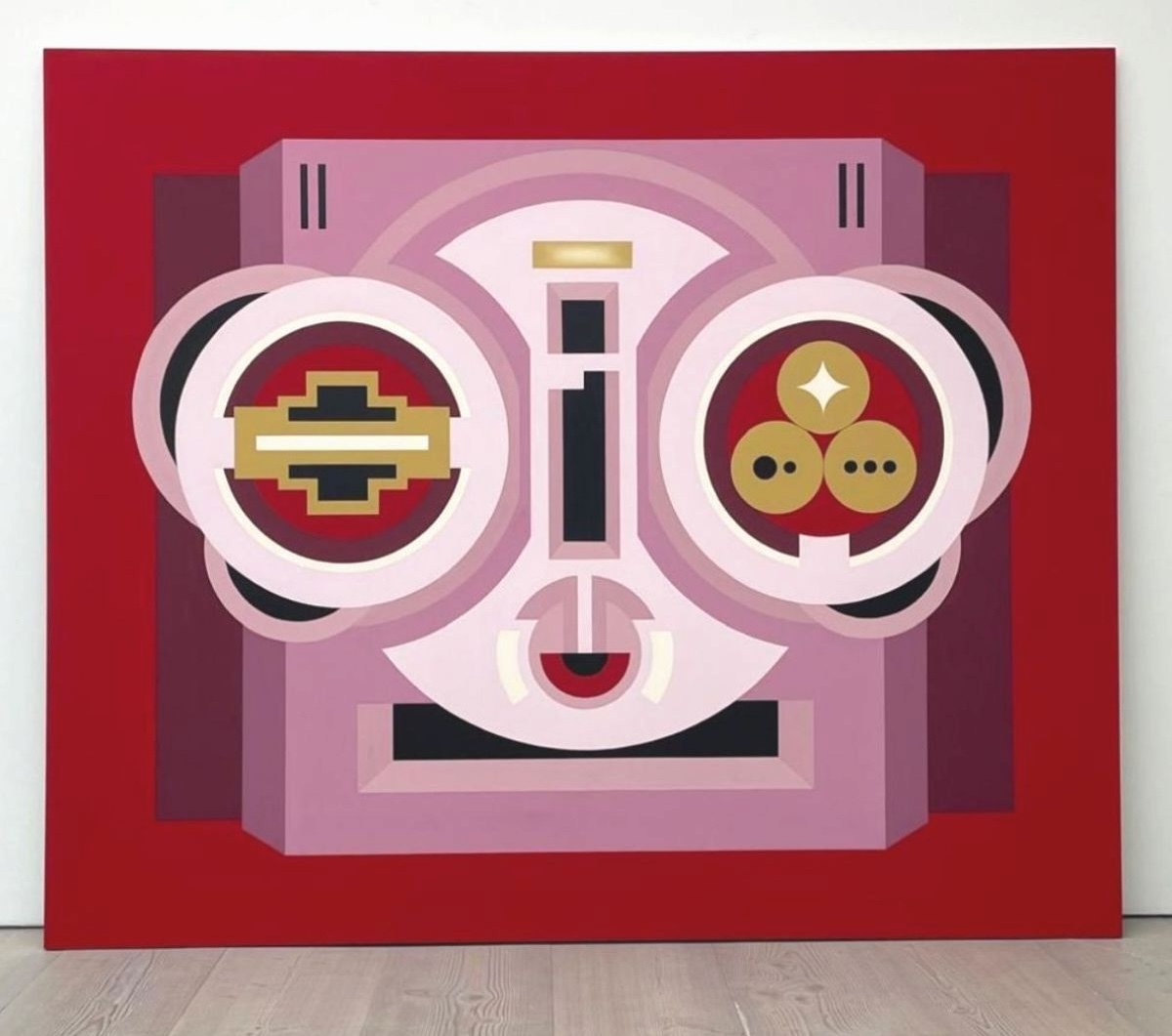 Hazel O'Sullivan: Lagore Crannóg, 2025, acrylic on canvas   250 x 300cm | Factory Made | Thursday 22 May  – Friday 18 July 2025 | Green On Red Gallery | Image: Hazel O'Sullivan: Lagore Crannóg, 2025, acrylic on canvas   250 x 300cm | very large canvas; we see it, face-on, leaning against a wall; background is a strong red; what is depicted is hard to decipher; it could be taken as the head of a robot wearing glam sunglasses with various geometrical shapes in its eyes … though the mouth is more of an eye…; the palette is is largely pale purple and white, but with reds, ochres, black, purple 