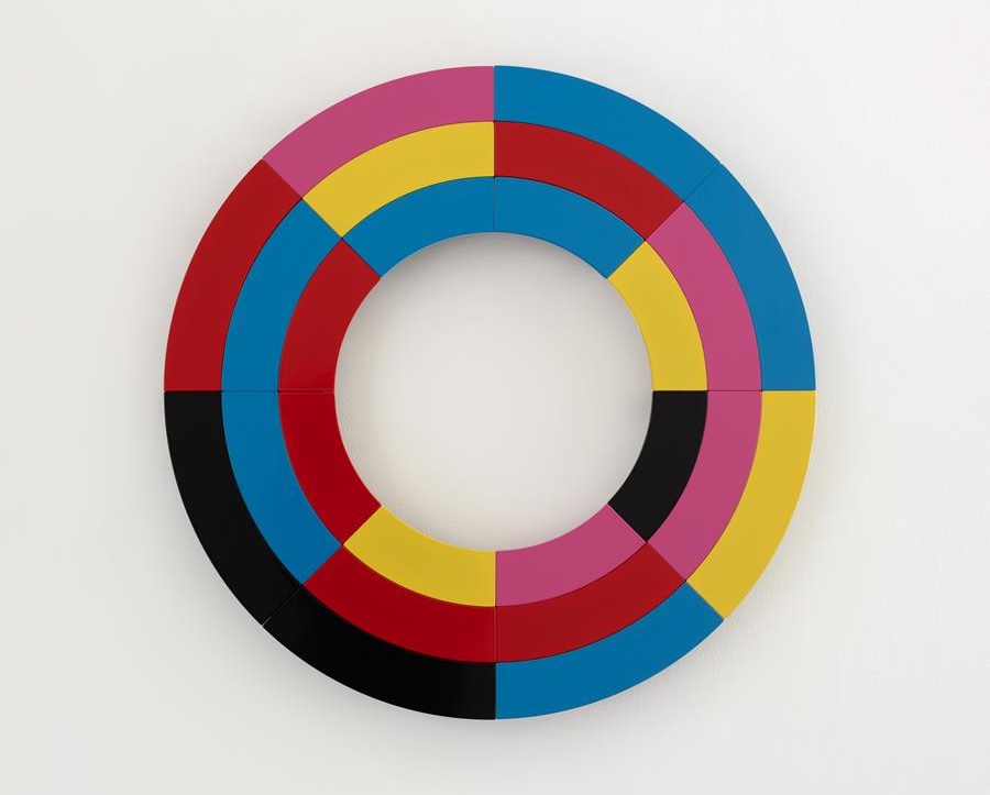 Liam Gillick, Vivid Production Cycle, 2025, powder-coated aluminium, 70 x 70 cm | Liam Gillick: À bientôt, j’espère… | Saturday 24 May  – Saturday 28 June 2025 | Kerlin Gallery | Image: Liam Gillick, Vivid Production Cycle, 2025, powder-coated aluminium, 70 x 70 cm | circular – donut-shaped – ‘canvas’; there are three concentric circles, each segmented into primary colours or black or pink, with the sections somewhat aligned; the wall behind is white   