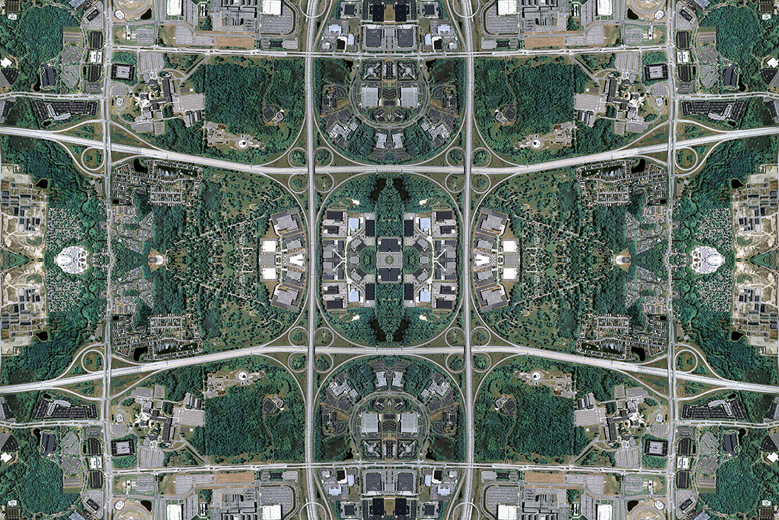 David Thomas Smith: Anthropocene | Saturday 6 September  – Saturday 25 October 2025 | Solstice Arts Centre | Image: overhead view of some sort of installation, with roads arouind it, but more to the point, there is lots of weaving together of images and mirror-imaging, creating a sort of rug-like patterning of buildings and trees and roads and grass 