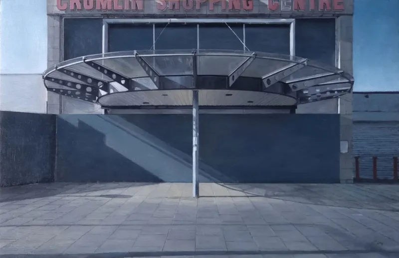 Francis Matthews: Crumlin, oil on board in artist-made steel frame, 22 x 34cm | Francis Matthews: Ext / Int | Saturday 21 March  – Thursday 23 April 2026 | Molesworth Gallery | Francis Matthews: Crumlin, oil on board in artist-made steel frame, 22 x 34cm | The painting is of the entrance to Crumlin Shopping Centre, done photo-realistically; a big splay of a canopy; but the entrance is boarded over, like so much in Dublin; grey board, board-up windows  