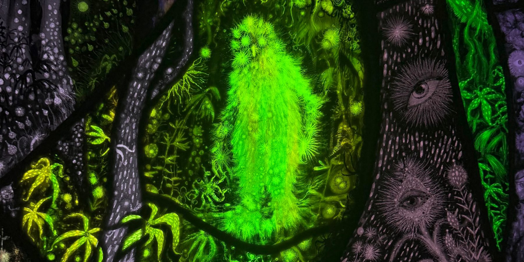 Rayleen Clancy: Wild Wisdom from a Grúagach’s Lair | Thursday 3 September  – Saturday 31 October 2026 | GOMA Gallery of Modern Art | a detail of an artwork, probably; it shows what looks to be a very hairy, glowing, green yeti in a forest setting against black; this appears like one motif in stained glass, and we see another motif – multiple eyes in purple against black – in an adjoining element 
